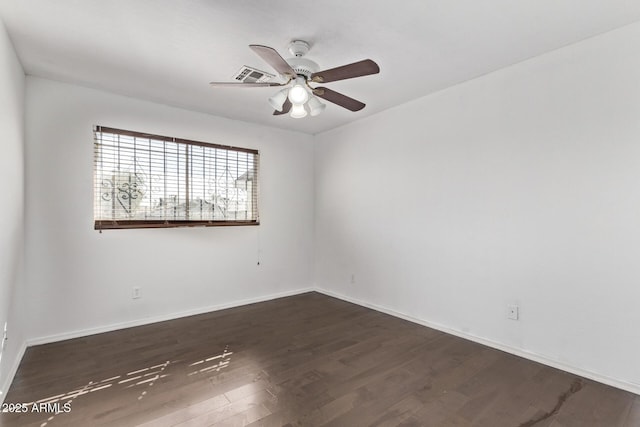 empty room featuring dark wood-style flooring, ceiling fan, and baseboards