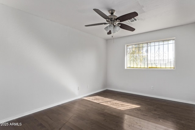 unfurnished room with ceiling fan, baseboards, and dark wood-type flooring