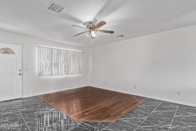 entryway featuring a ceiling fan, marble finish floors, and baseboards