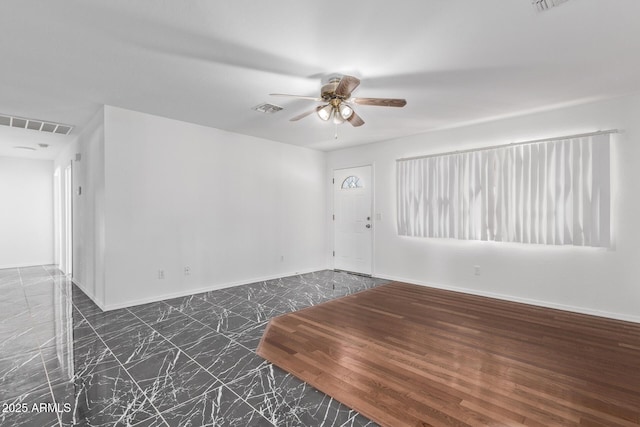 unfurnished room with ceiling fan, baseboards, and marble finish floors