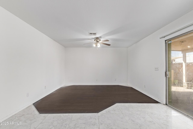 spare room featuring a ceiling fan, baseboards, and marble look tile flooring