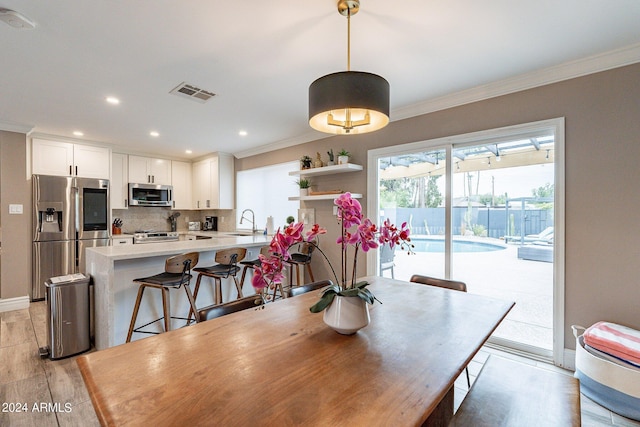 dining space featuring recessed lighting, visible vents, baseboards, ornamental molding, and light wood finished floors