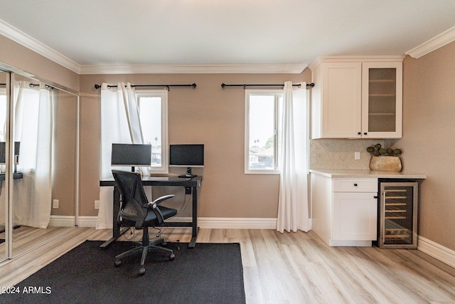 office area featuring beverage cooler, ornamental molding, baseboards, and light wood-style floors