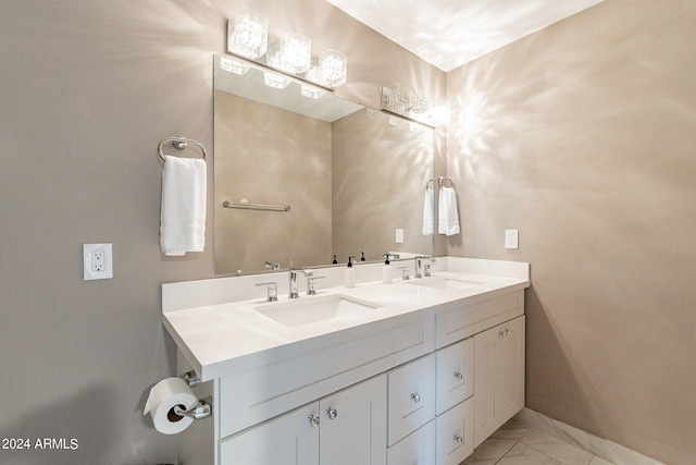 bathroom with double vanity, marble finish floor, baseboards, and a sink