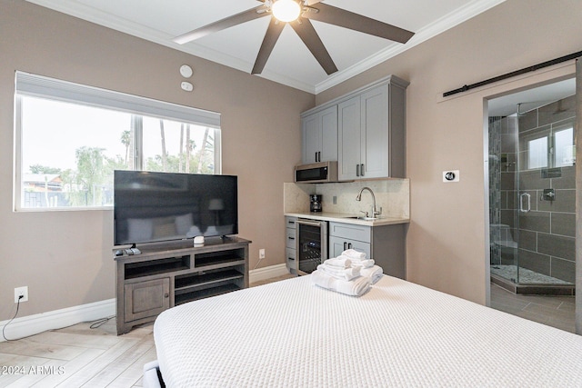 bedroom featuring wine cooler, a sink, crown molding, and baseboards