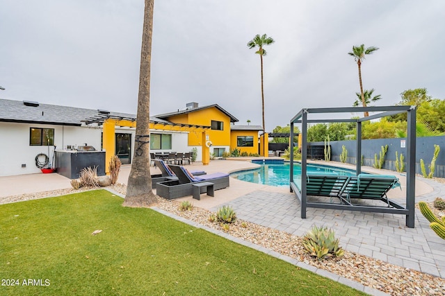 view of swimming pool with a fenced in pool, fence, exterior kitchen, a patio area, and a pergola