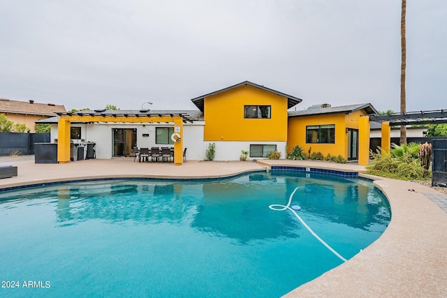 outdoor pool featuring fence, a pergola, and a patio