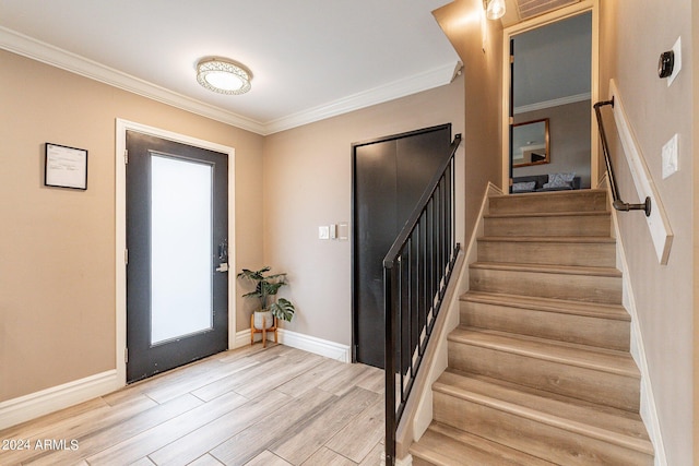 entryway featuring visible vents, baseboards, light wood-style floors, ornamental molding, and stairway