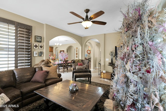 living room featuring ceiling fan with notable chandelier and tile patterned floors