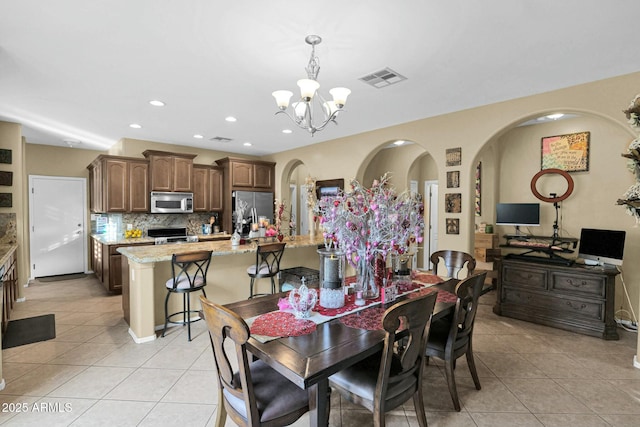 tiled dining area featuring an inviting chandelier