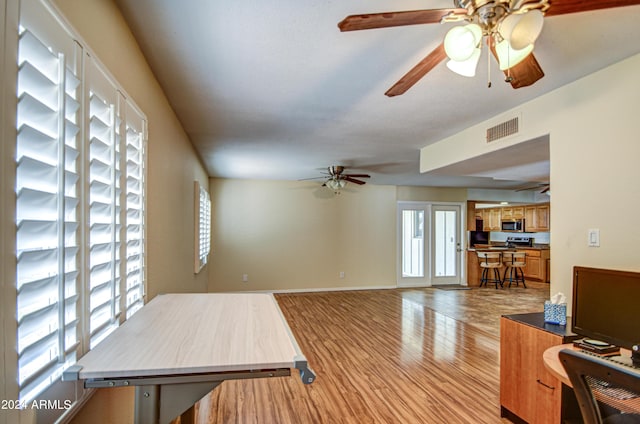 living room with ceiling fan and light hardwood / wood-style flooring