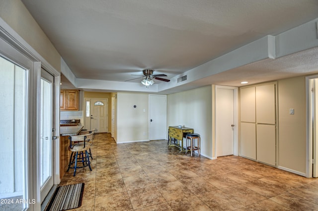 interior space with ceiling fan and a textured ceiling