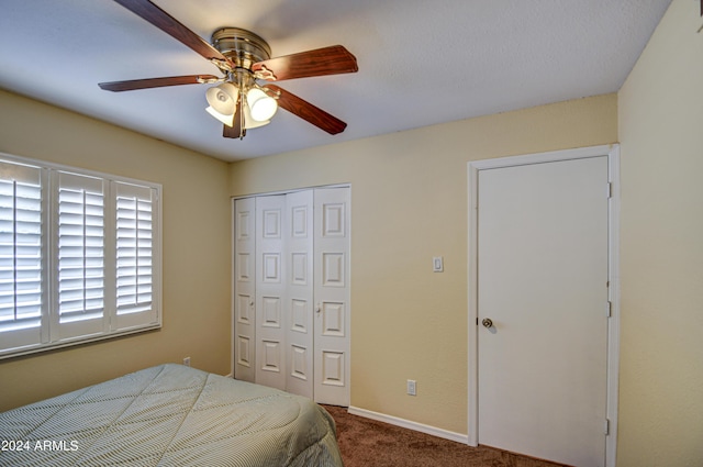 carpeted bedroom featuring ceiling fan and a closet