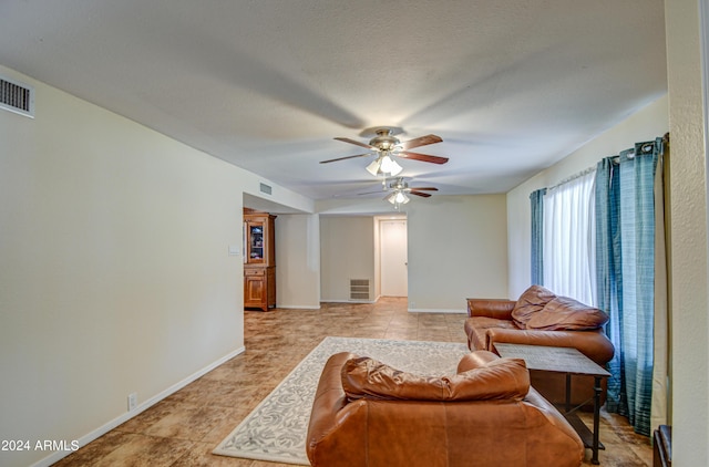 living room with ceiling fan and light tile patterned floors