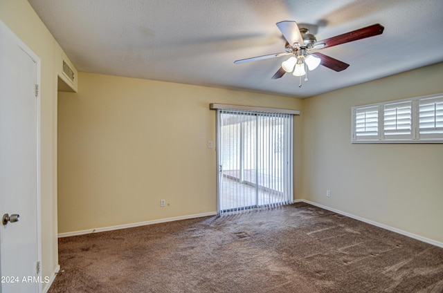 unfurnished room featuring dark carpet and ceiling fan