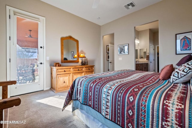 bedroom with access to exterior, visible vents, light carpet, ensuite bathroom, and a ceiling fan