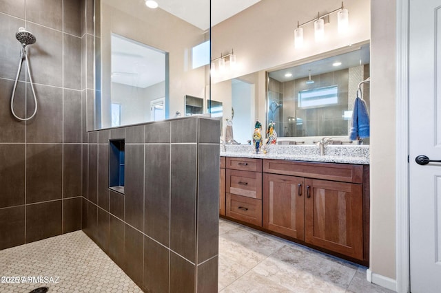 bathroom with tile patterned flooring, vanity, and walk in shower