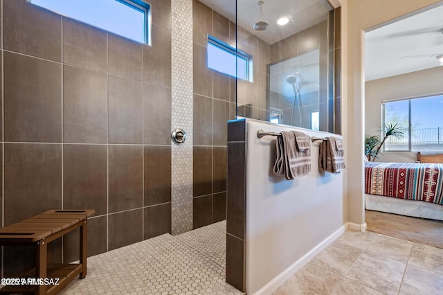 ensuite bathroom with tile patterned floors, a walk in shower, ensuite bathroom, and baseboards