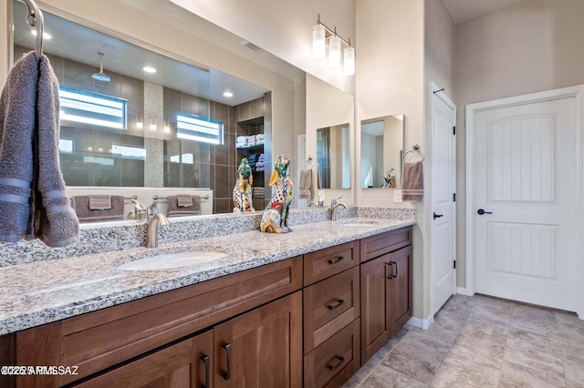 bathroom featuring a sink, visible vents, tiled shower, and double vanity