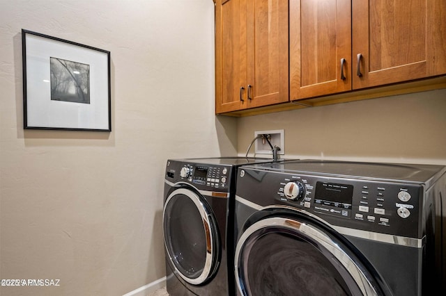 laundry room with washer and dryer, baseboards, and cabinet space