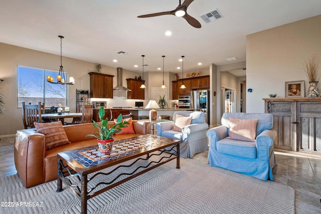 living room with ceiling fan with notable chandelier, recessed lighting, and visible vents