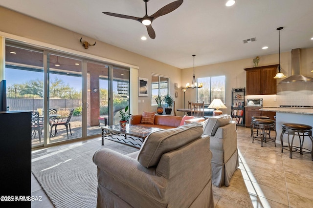 living room with recessed lighting, ceiling fan with notable chandelier, visible vents, and light tile patterned flooring