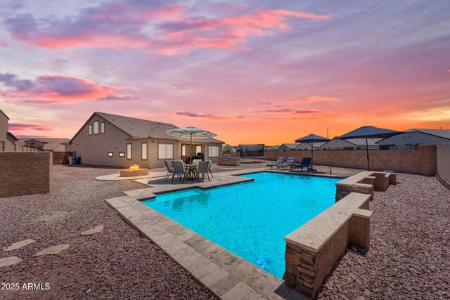 23886 W Harrison Dr, Buckeye, AZ 85326 - pool at dusk with a patio area and a fenced backyard
