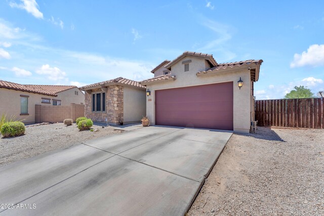 23886 W Harrison Dr, Buckeye, AZ 85326 - mediterranean / spanish house with stucco siding, concrete driveway, a tiled roof, an attached garage, and stone siding