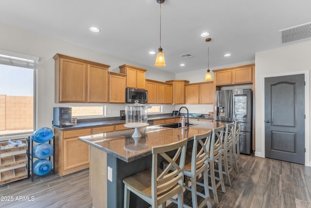 23886 W Harrison Dr, Buckeye, AZ 85326 - kitchen with stainless steel appliances, dark wood-style floors, a kitchen island with sink, a kitchen breakfast bar, and recessed lighting