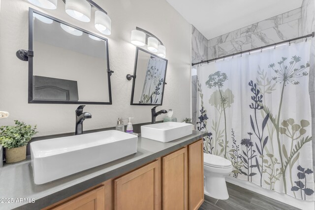 23886 W Harrison Dr, Buckeye, AZ 85326 - full bathroom with double vanity, a shower with curtain, and wood finished floors