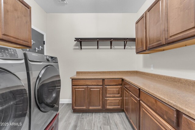 23886 W Harrison Dr, Buckeye, AZ 85326 - laundry room featuring cabinet space, washing machine and dryer, and light wood-style flooring