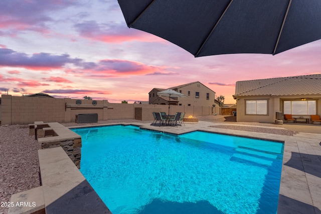 23886 W Harrison Dr, Buckeye, AZ 85326 - pool at dusk featuring a patio area and a fenced backyard