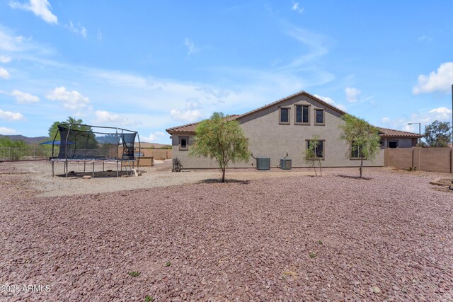 23886 W Harrison Dr, Buckeye, AZ 85326 - rear view of house with a trampoline, a fenced backyard, stucco siding, and a tile roof
