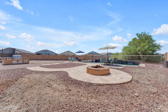 23886 W Harrison Dr, Buckeye, AZ 85326 - fenced backyard featuring a patio area, a fire pit, and area for grilling