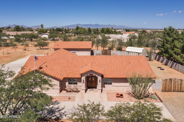 view of front of property with a fenced backyard, a mountain view, and stucco siding