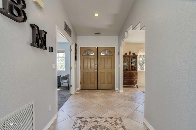 entryway with visible vents, baseboards, and light tile patterned floors