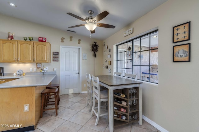 dining area featuring light tile patterned floors, lofted ceiling, a ceiling fan, and baseboards