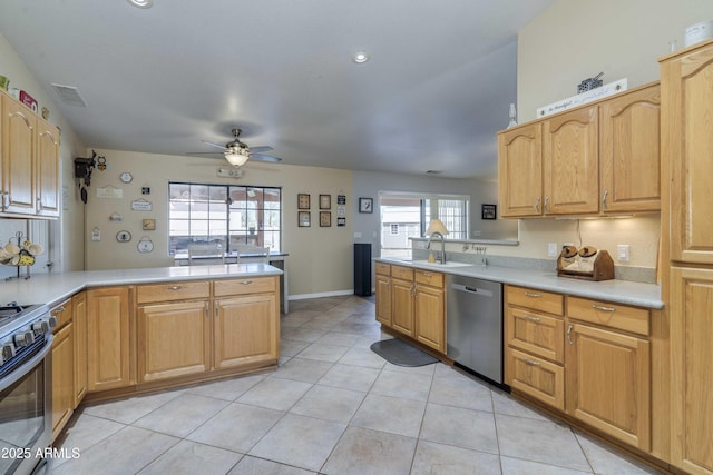 kitchen with light tile patterned flooring, a peninsula, visible vents, light countertops, and appliances with stainless steel finishes