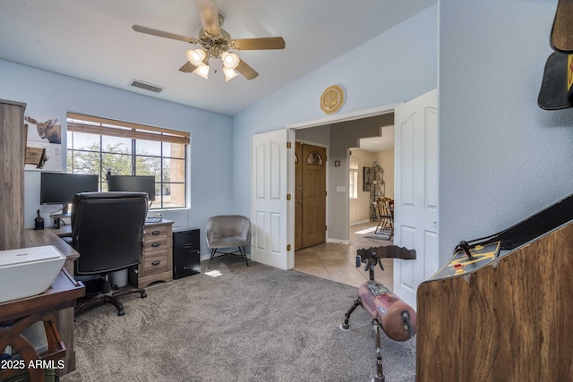 office featuring visible vents, a ceiling fan, light colored carpet, lofted ceiling, and light tile patterned flooring