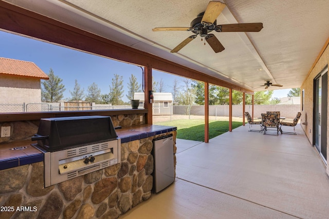 view of patio with a ceiling fan, outdoor dining area, a fenced backyard, and grilling area