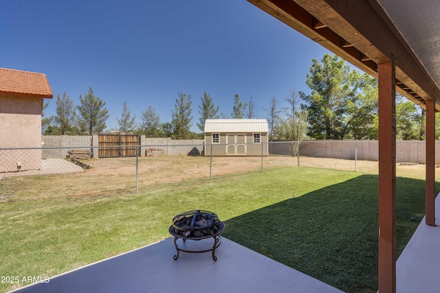 view of yard with an outbuilding, an outdoor fire pit, a patio area, and a fenced backyard