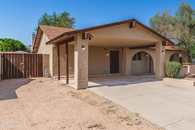 7340 W Meadowbrook Ave, Phoenix, AZ 85033 - view of front facade featuring stucco siding, a gate, concrete driveway, a carport, and a chimney
