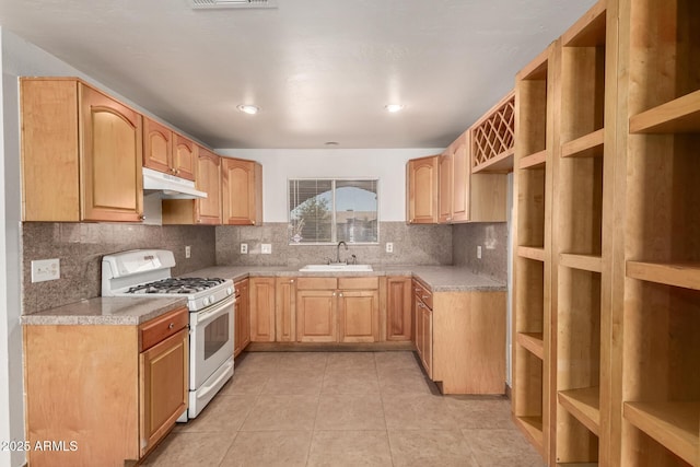 7340 W Meadowbrook Ave, Phoenix, AZ 85033 - kitchen featuring white gas range, a sink, under cabinet range hood, tasteful backsplash, and light tile patterned floors