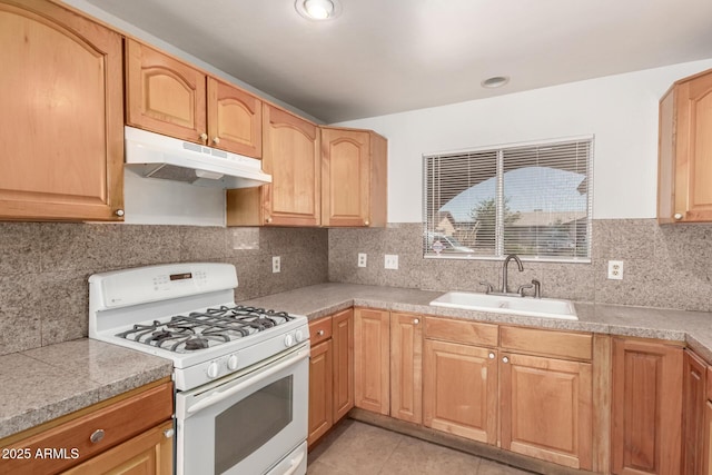 7340 W Meadowbrook Ave, Phoenix, AZ 85033 - kitchen featuring white gas range oven, under cabinet range hood, a sink, tile counters, and light tile patterned floors