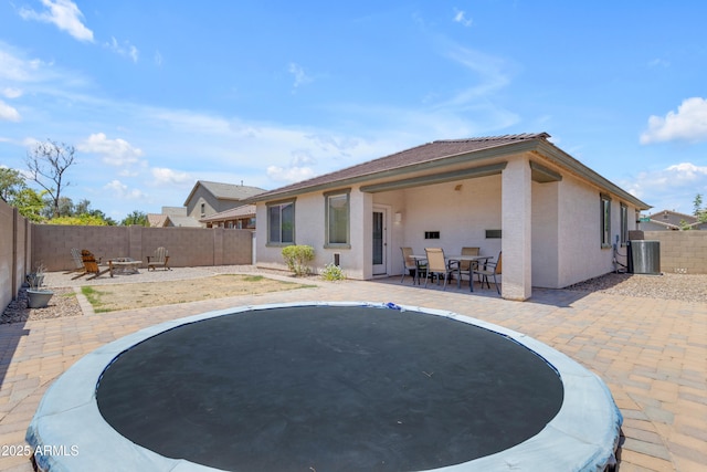 11159 E Sebring Ave, Mesa, AZ 85212 - rear view of house featuring a trampoline, a fenced backyard, a patio area, and outdoor dining space