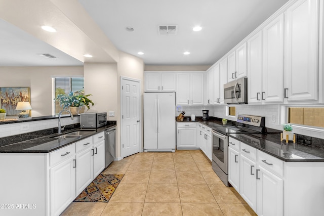 11159 E Sebring Ave, Mesa, AZ 85212 - kitchen with appliances with stainless steel finishes, decorative backsplash, white cabinets, a peninsula, and recessed lighting