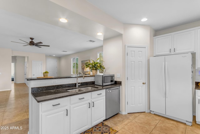 11159 E Sebring Ave, Mesa, AZ 85212 - kitchen with stainless steel appliances, a peninsula, dark stone counters, white cabinetry, and recessed lighting