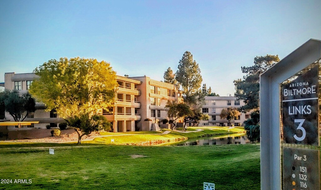 surrounding community featuring a water view and a lawn