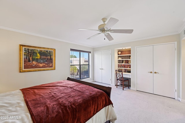 carpeted bedroom featuring crown molding, multiple closets, and ceiling fan