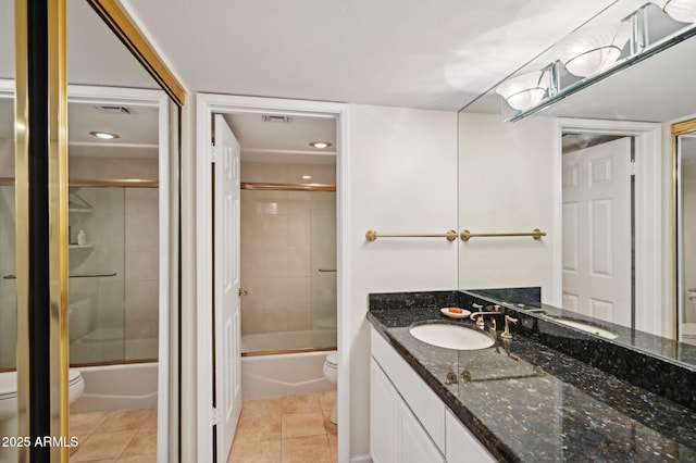 full bathroom with toilet, tile patterned floors, bath / shower combo with glass door, and vanity